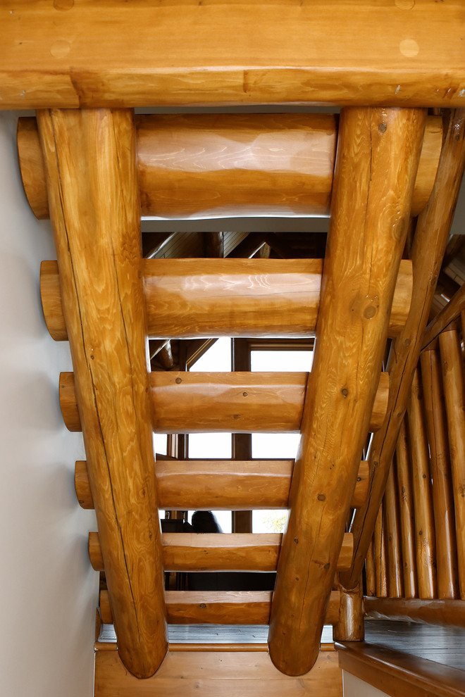 This is an example of a mid-sized country wood straight staircase in Other with open risers and wood railing.
