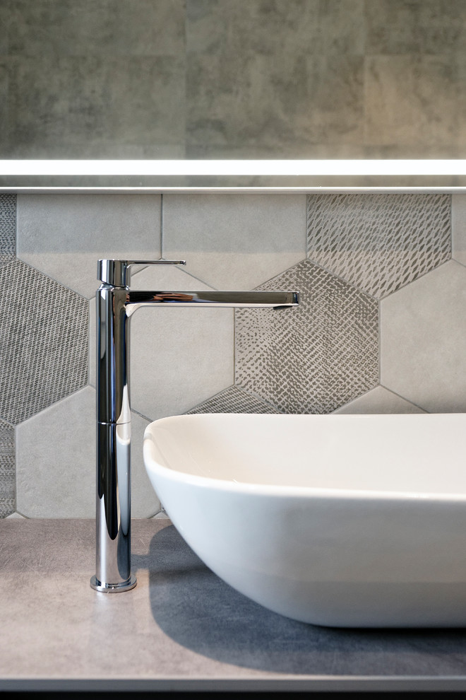 Inspiration for a mid-sized contemporary 3/4 bathroom in Milan with flat-panel cabinets, grey cabinets, a two-piece toilet, gray tile, ceramic tile, grey walls, porcelain floors, a vessel sink, brown floor and an open shower.