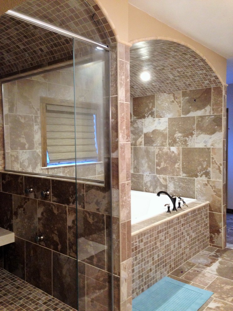 Inspiration for a transitional master multicolored tile and porcelain tile porcelain tile drop-in bathtub remodel with an integrated sink, recessed-panel cabinets, distressed cabinets, solid surface countertops and beige walls