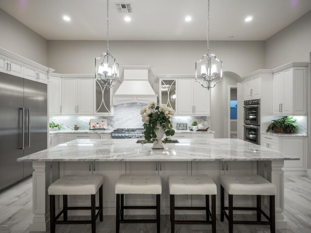 Mid-sized transitional u-shaped marble floor and gray floor eat-in kitchen photo in Phoenix with an undermount sink, raised-panel cabinets, white cabinets, marble countertops, white backsplash, marble backsplash, stainless steel appliances, an island and gray countertops