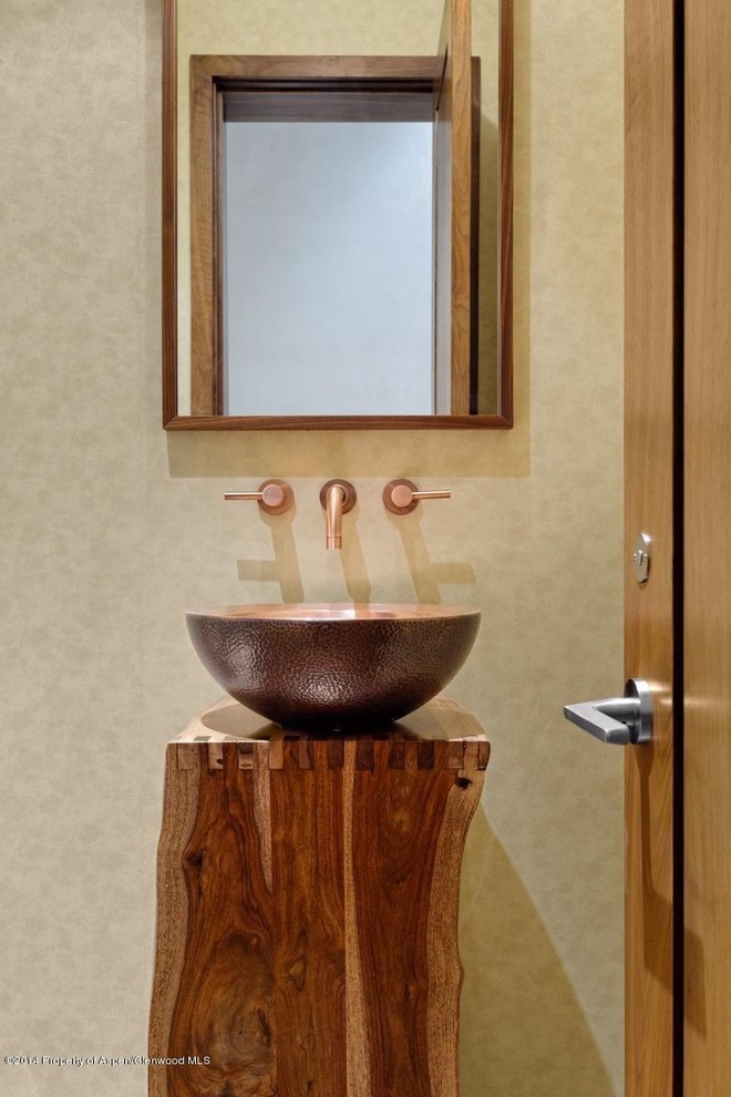 Inspiration for a small contemporary powder room in Denver with furniture-like cabinets, medium wood cabinets, a one-piece toilet, beige walls, light hardwood floors, a vessel sink and wood benchtops.