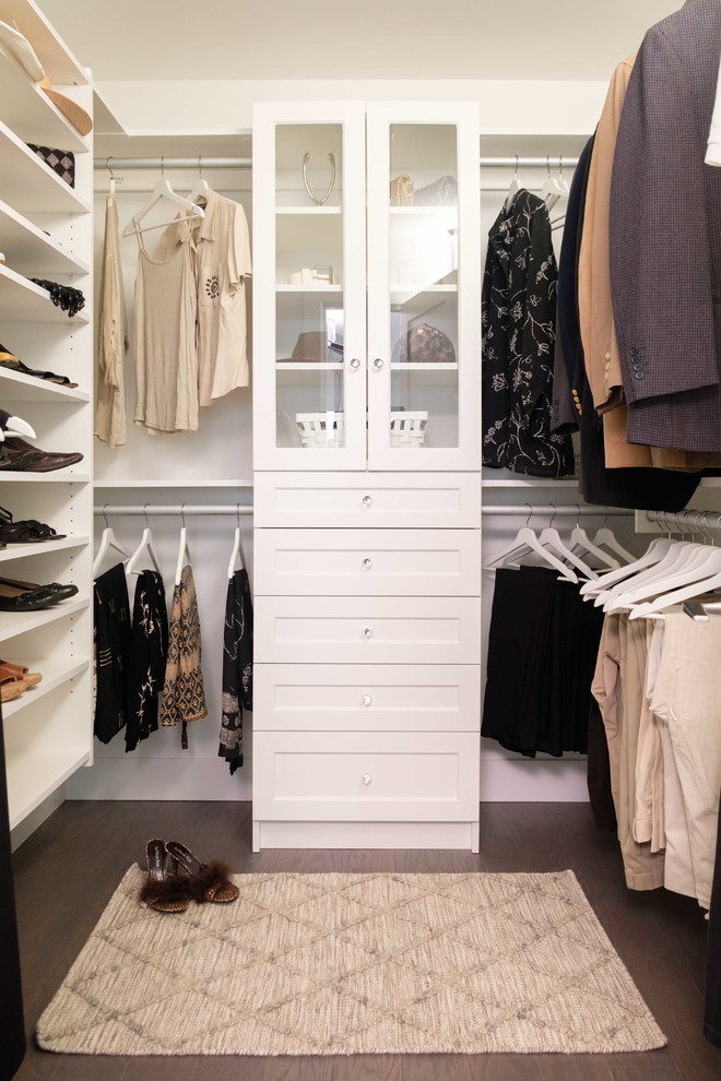 This is an example of a large gender-neutral walk-in wardrobe in Vancouver with shaker cabinets, white cabinets, medium hardwood floors and brown floor.