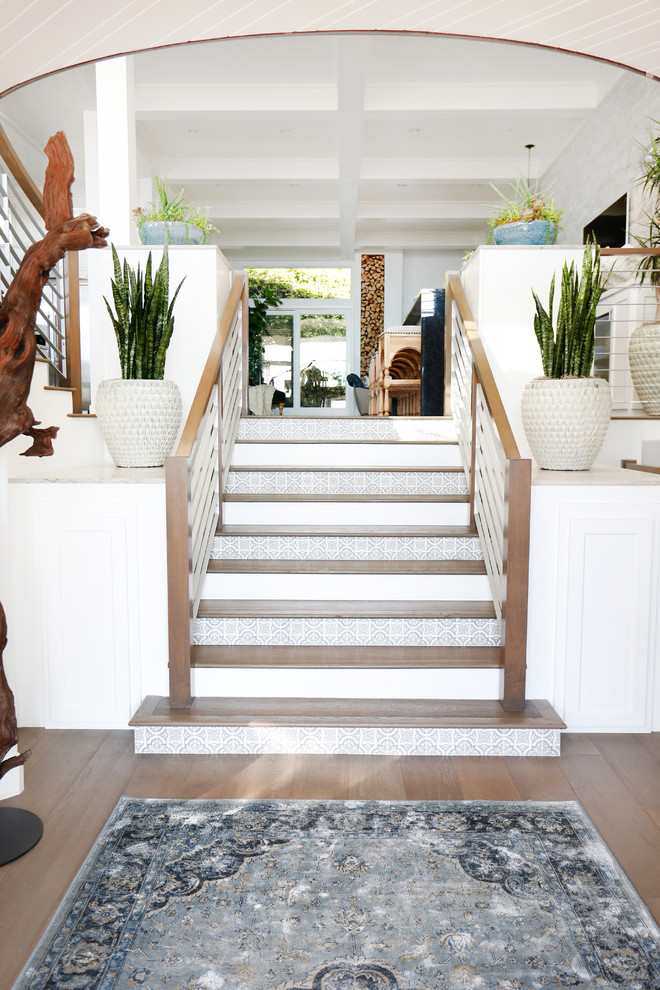 Example of a mid-sized beach style medium tone wood floor foyer design in Orange County with white walls and a dark wood front door