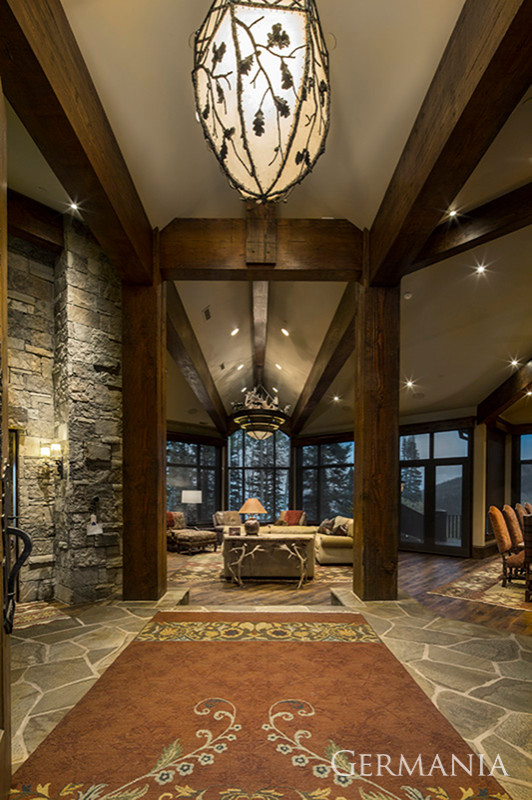Country foyer in Salt Lake City with beige walls, slate floors and exposed beam.