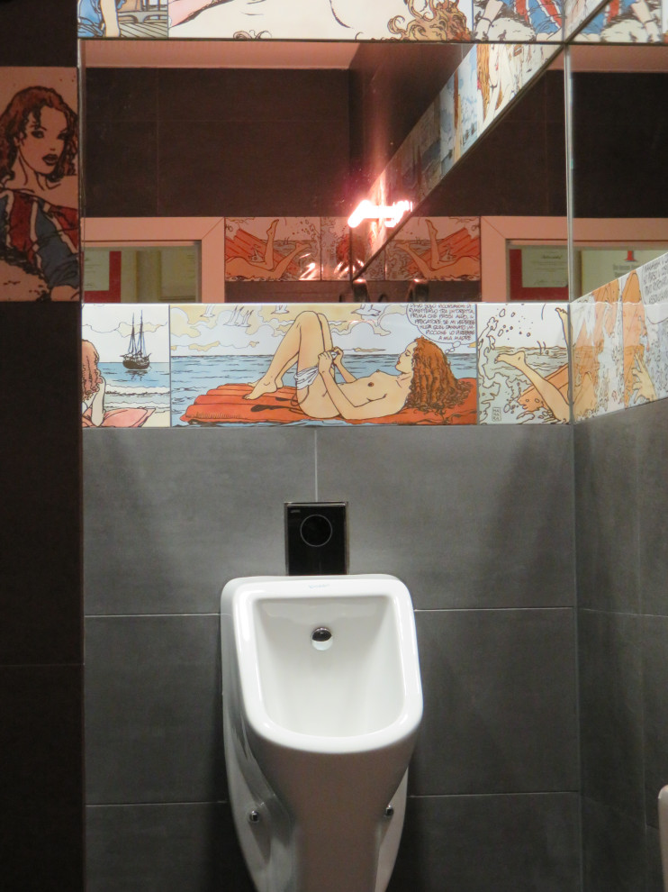 На фото: туалет среднего размера в стиле фьюжн с инсталляцией, черной плиткой, керамической плиткой, черными стенами, полом из керамической плитки, подвесной раковиной, стеклянной столешницей, черным полом, подвесной тумбой и многоуровневым потолком с