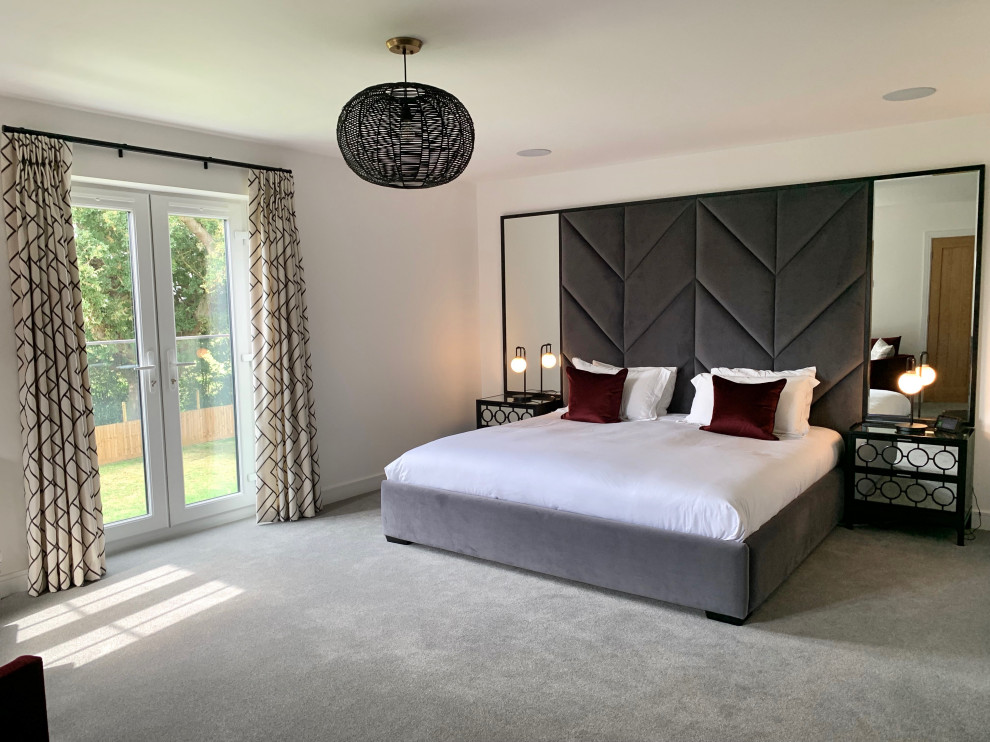 Large contemporary master bedroom in Hertfordshire with white walls, carpet and grey floors.