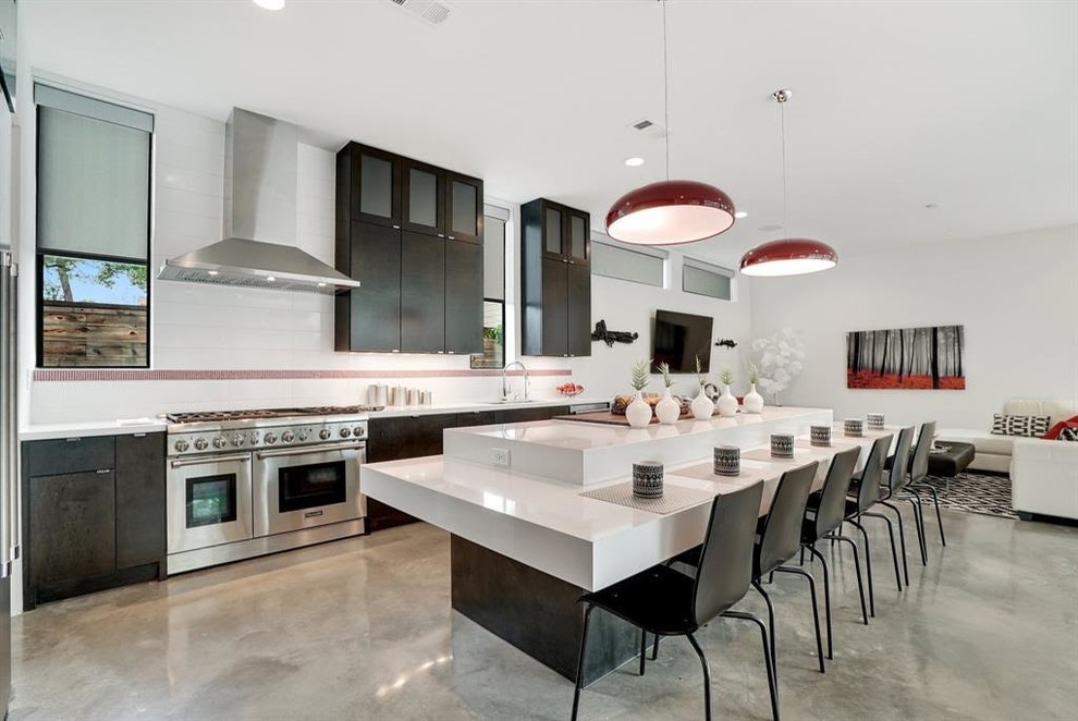 Inspiration for a mid-sized modern l-shaped open plan kitchen in Houston with an undermount sink, flat-panel cabinets, dark wood cabinets, quartz benchtops, white splashback, ceramic splashback, stainless steel appliances, concrete floors, with island, white benchtop and grey floor.