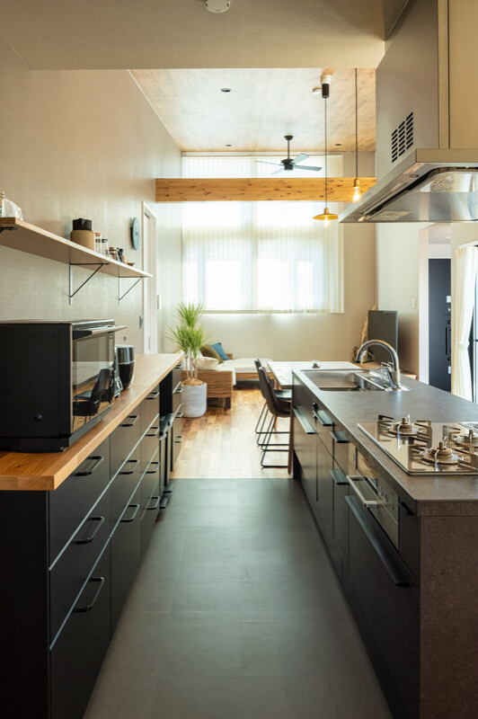 Стильный дизайн: параллельная кухня-гостиная среднего размера в восточном стиле с врезной мойкой, серым фартуком, черной техникой, островом, черным полом, коричневой столешницей и потолком с обоями - последний тренд