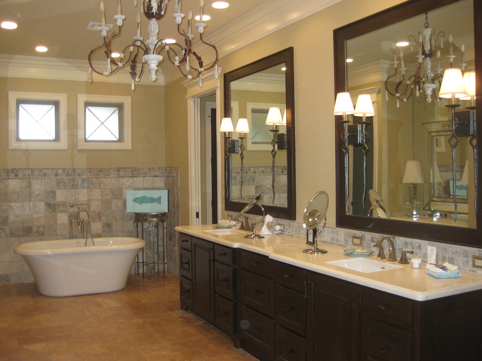 This is an example of a mid-sized transitional master bathroom in Houston with recessed-panel cabinets, dark wood cabinets, a freestanding tub, gray tile, ceramic tile, beige walls, ceramic floors, an undermount sink and engineered quartz benchtops.