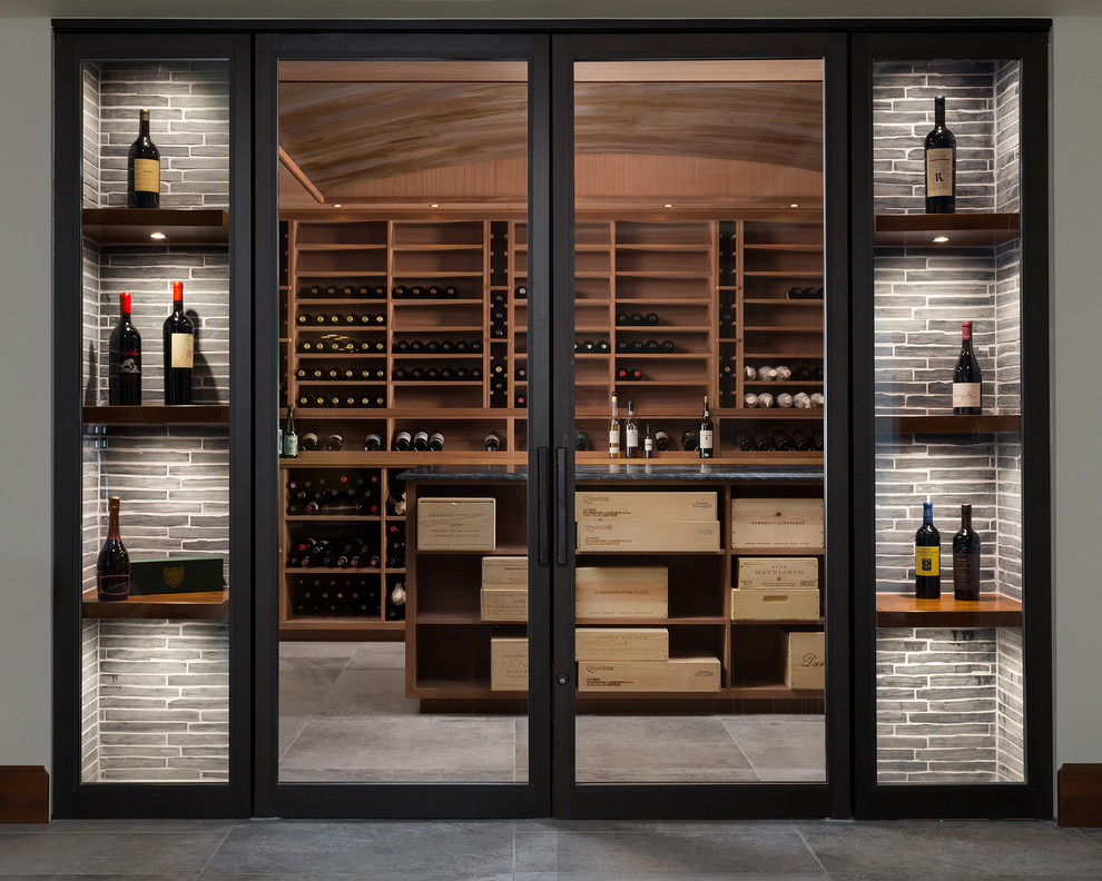 Photo of a mid-sized modern wine cellar in Denver with concrete floors, storage racks and grey floor.