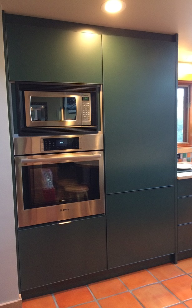 Inspiration for a large rustic l-shaped terra-cotta tile open concept kitchen remodel in Vancouver with an undermount sink, flat-panel cabinets, green cabinets, quartz countertops, terra-cotta backsplash and an island