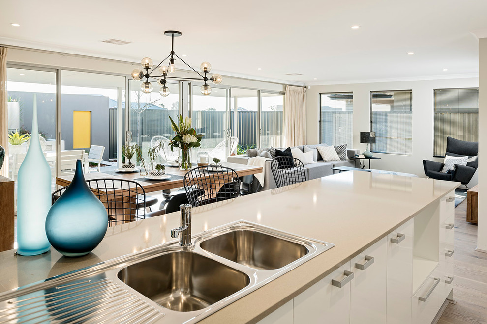This is an example of a mid-sized contemporary kitchen/dining combo in Perth with white walls and light hardwood floors.