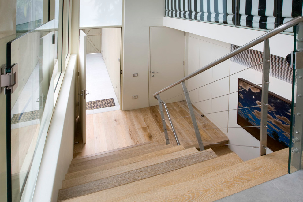 Photo of a small contemporary wood u-shaped staircase in Sydney with open risers and cable railing.