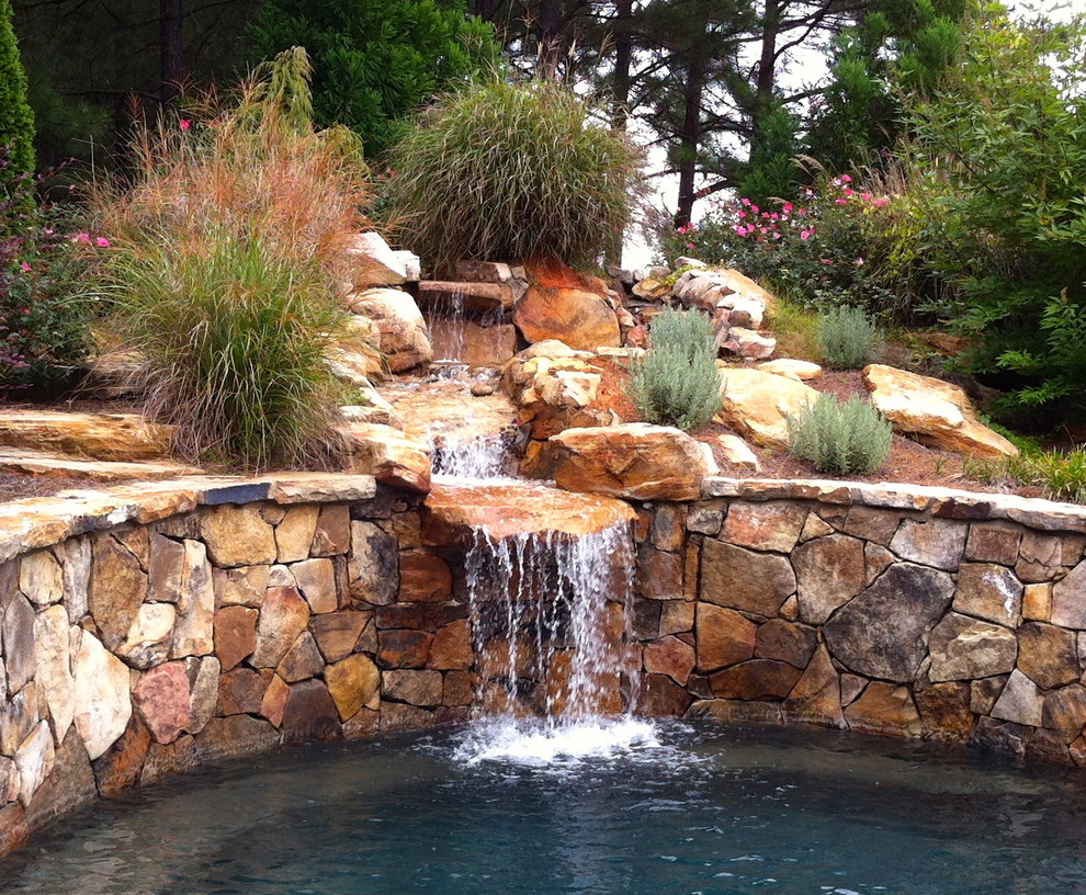 Photo of a traditional sloped garden in Atlanta with a water feature.