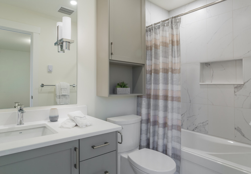 Inspiration for a small transitional master bathroom in Vancouver with shaker cabinets, grey cabinets, an alcove tub, a one-piece toilet, black and white tile, porcelain tile, white walls, porcelain floors, a wall-mount sink, engineered quartz benchtops and white floor.