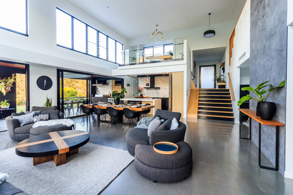 Large contemporary open concept living room in Sunshine Coast with concrete floors and grey floor.