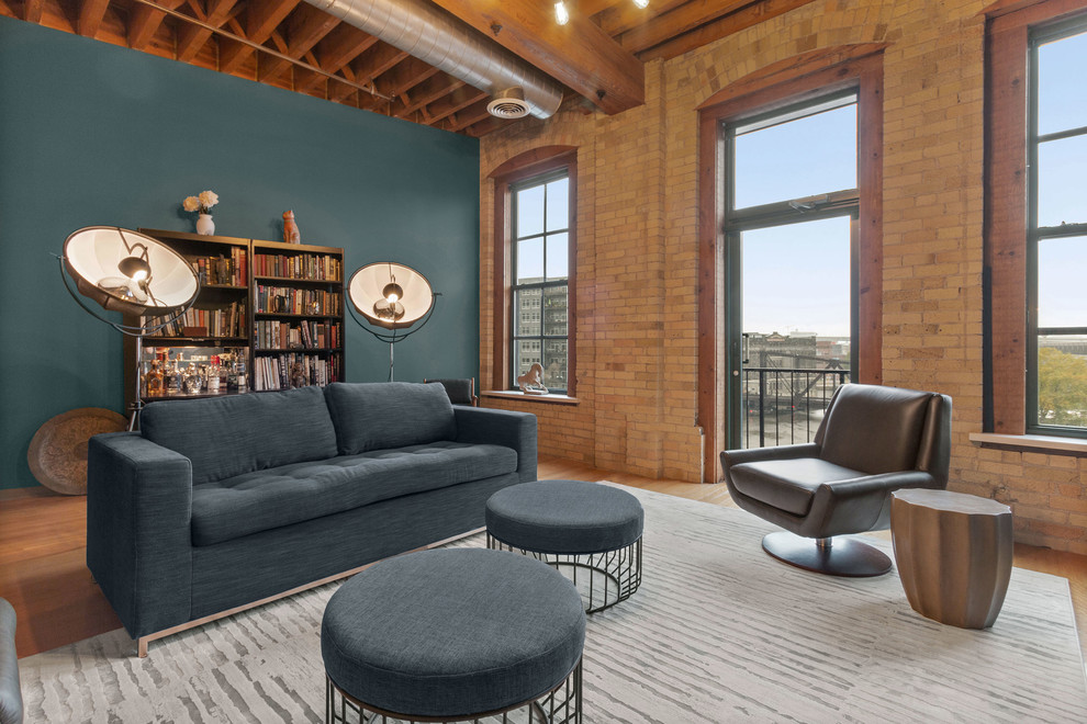 This is an example of a mid-sized industrial open concept living room in Milwaukee with medium hardwood floors, brown floor and blue walls.