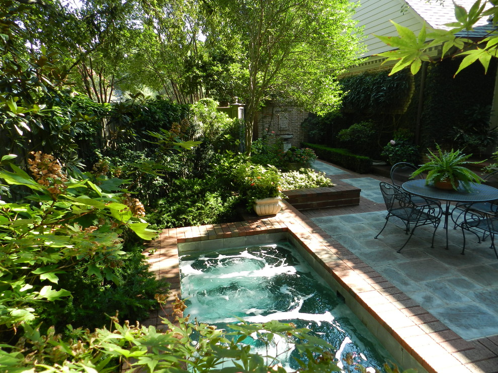 Inspiration for a traditional courtyard garden in Dallas with a water feature.