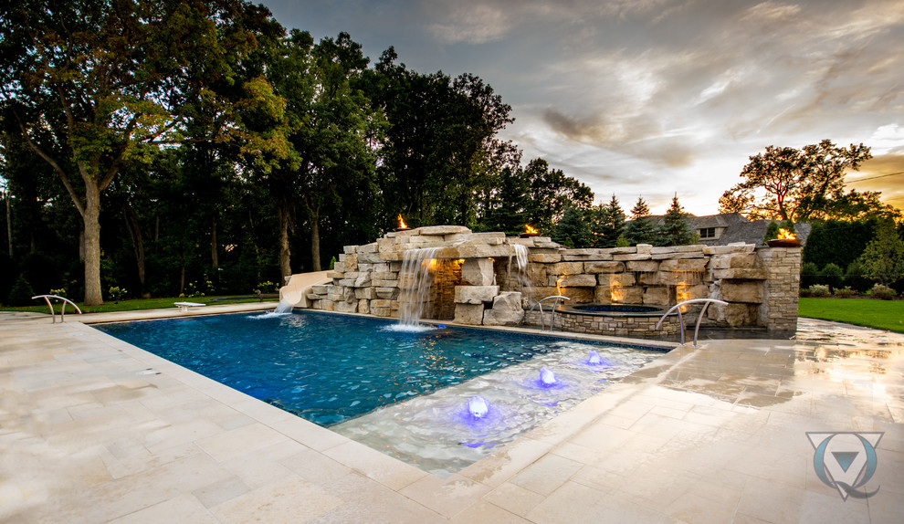 Example of a large mountain style backyard stone and rectangular natural pool fountain design in Chicago