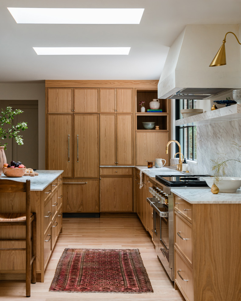 Inspiration for a mid-sized transitional l-shaped light wood floor eat-in kitchen remodel in Chicago with an undermount sink, shaker cabinets, light wood cabinets, marble countertops, white backsplash, marble backsplash, paneled appliances, an island and white countertops