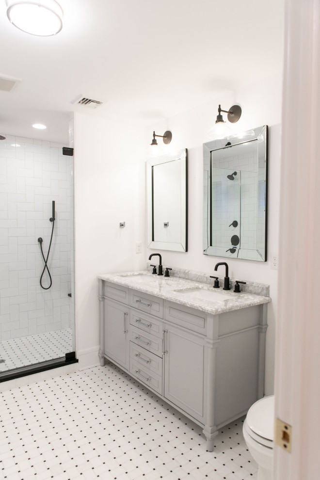 Alcove shower - mid-sized transitional master ceramic tile, white floor and double-sink alcove shower idea in New York with shaker cabinets, gray cabinets, a one-piece toilet, white walls, an undermount sink, quartz countertops, a hinged shower door, gray countertops and a freestanding vanity