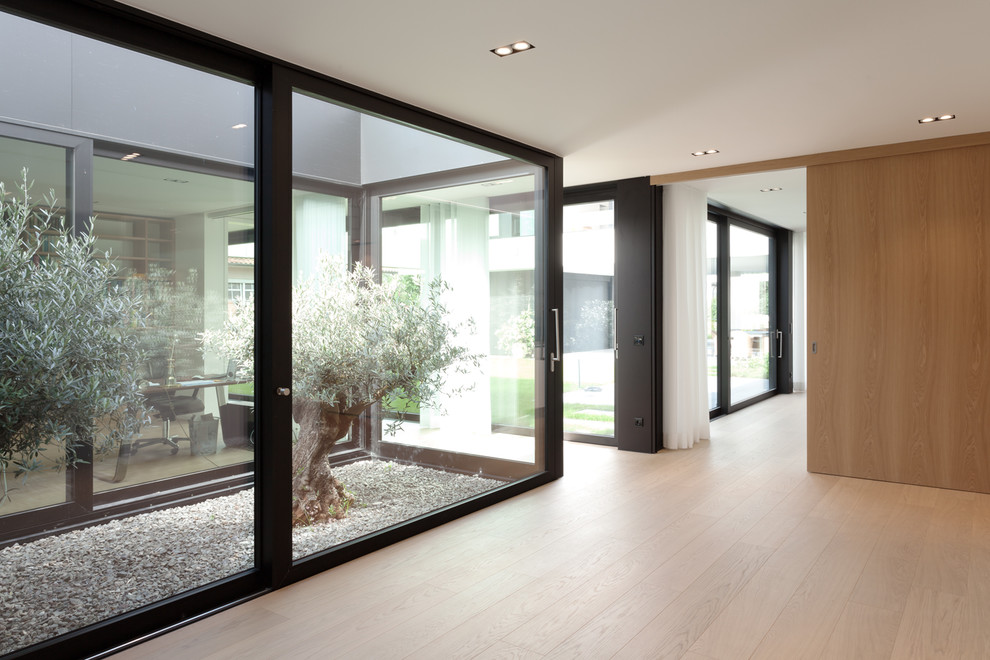 Design ideas for a mid-sized modern hallway in Dortmund with white walls, medium hardwood floors and beige floor.