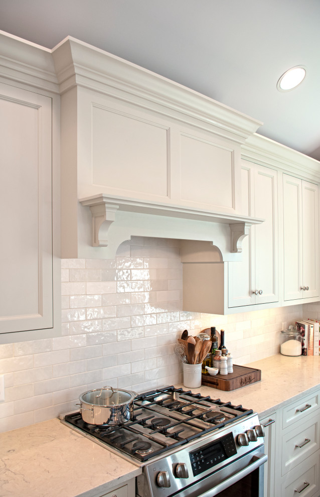 Transitional vaulted ceiling eat-in kitchen photo with shaker cabinets, white cabinets, quartz countertops, white backsplash, ceramic backsplash, stainless steel appliances and white countertops