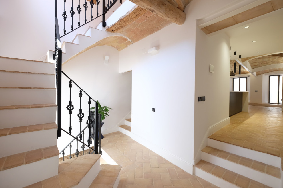 バルセロナにあるラグジュアリーな広いラスティックスタイルのおしゃれな直階段 (金属の手すり、レンガ壁) の写真