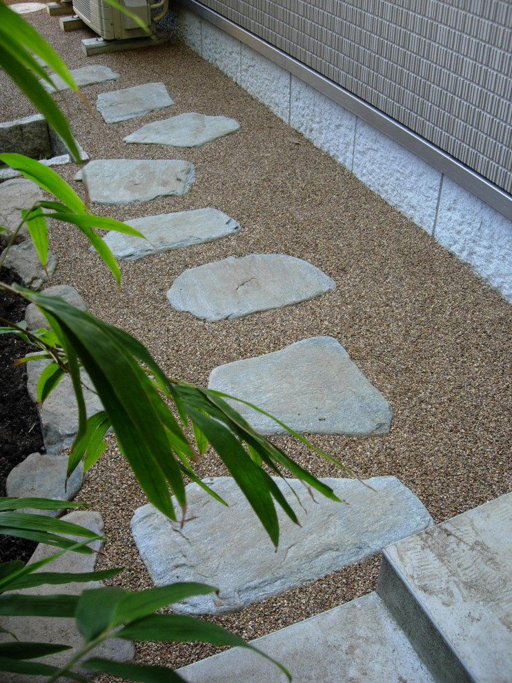 Large traditional sloped partial sun garden in Other with with rock feature and natural stone pavers for spring.