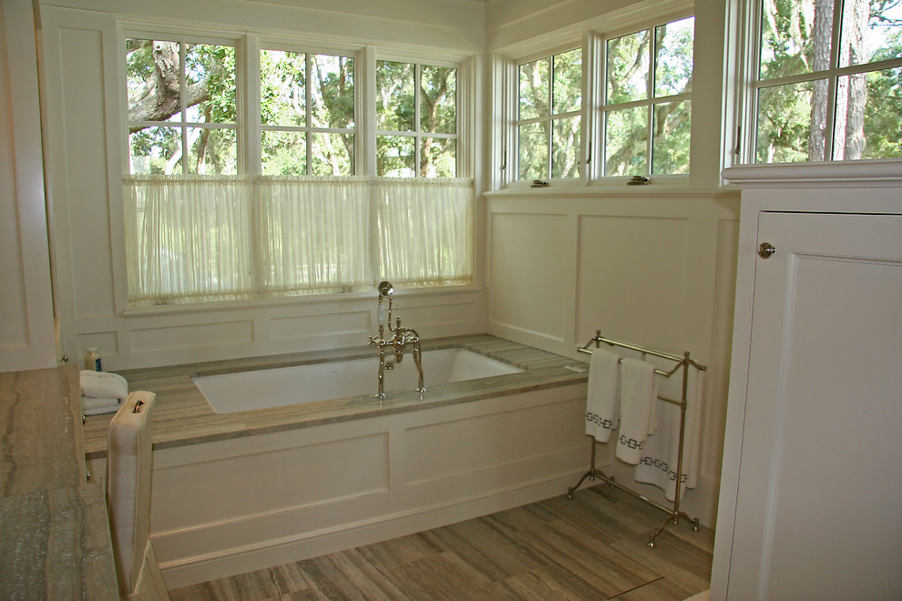 Eclectic bathroom in Atlanta with white cabinets, an undermount tub, gray tile, stone tile and an undermount sink.