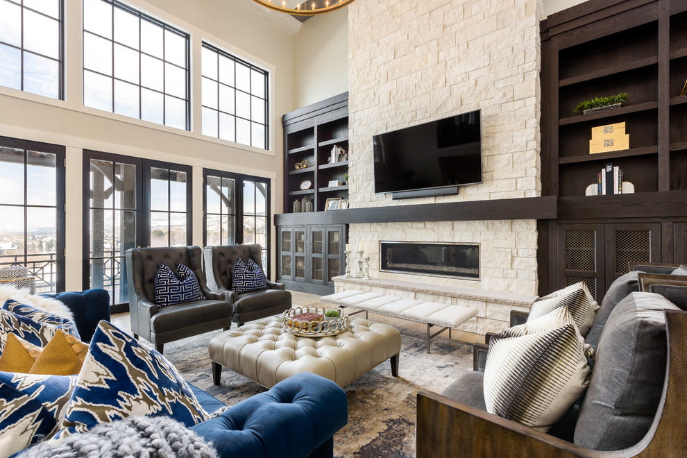 Photo of a large transitional open concept family room in Salt Lake City with beige walls, light hardwood floors, a stone fireplace surround, a wall-mounted tv, a ribbon fireplace and brown floor.