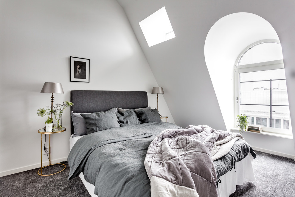 Mid-sized scandinavian master bedroom in Stockholm with white walls and carpet.
