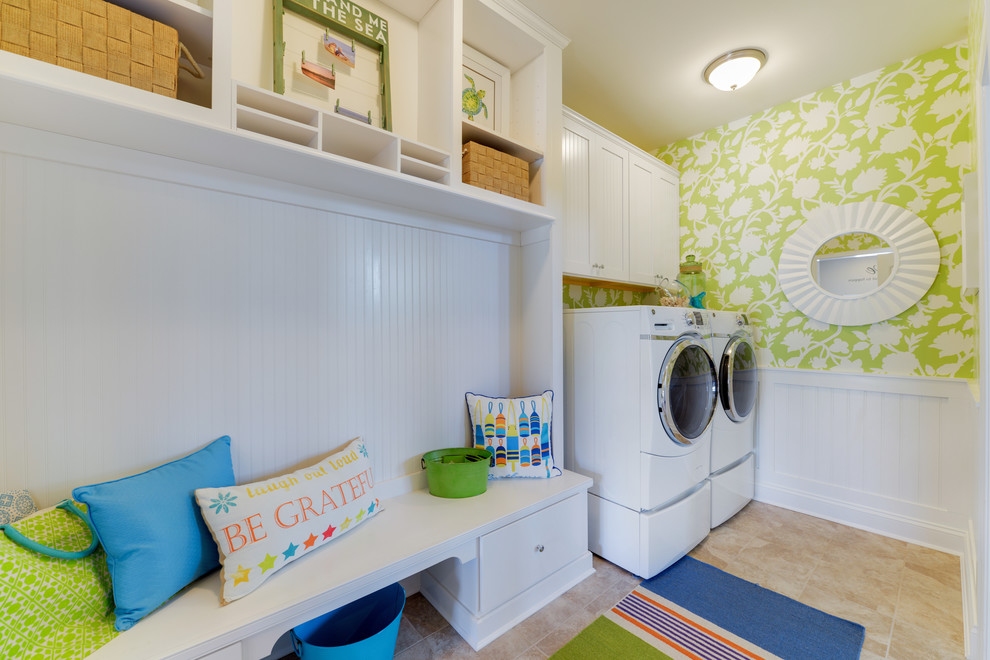 Photo of a beach style single-wall utility room in Philadelphia with white cabinets, green walls and a side-by-side washer and dryer.