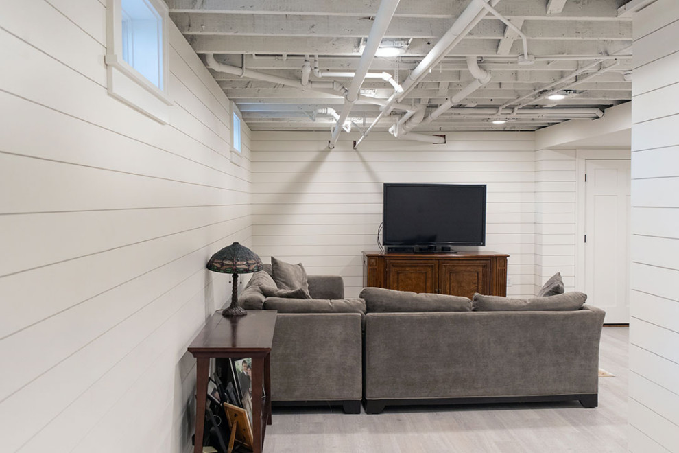 Large transitional underground vinyl floor, beige floor and shiplap wall basement photo in Other with white walls