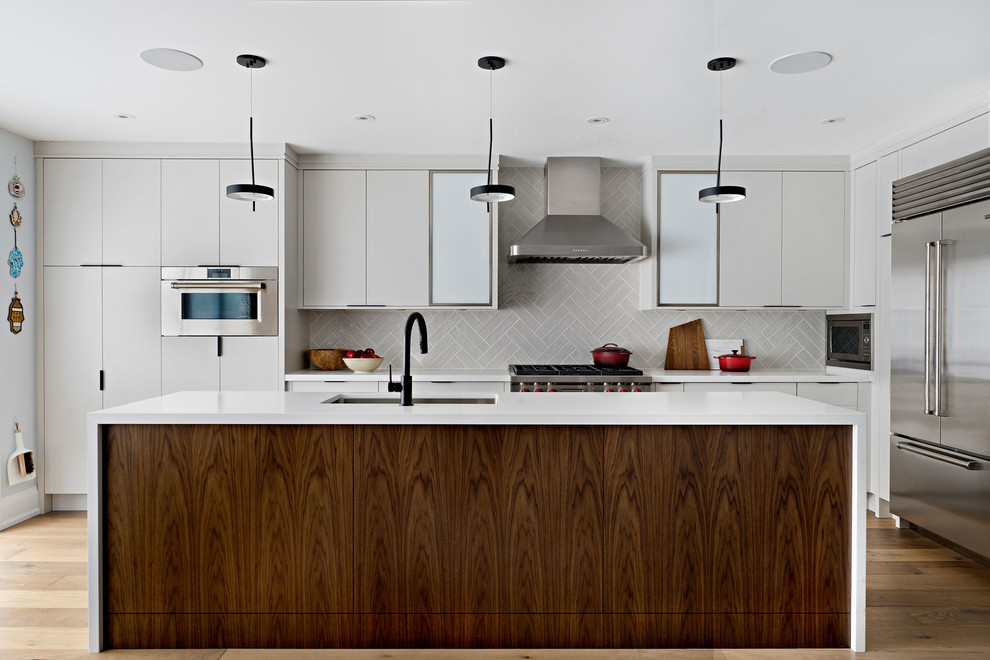 Inspiration for a mid-sized contemporary l-shaped light wood floor and brown floor open concept kitchen remodel in Toronto with an undermount sink, flat-panel cabinets, gray cabinets, quartz countertops, gray backsplash, ceramic backsplash, stainless steel appliances, an island and white countertops