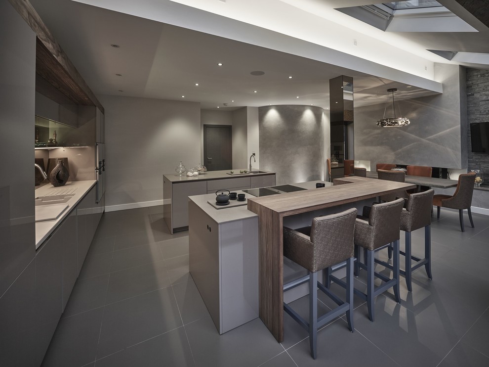 This is an example of a large contemporary single-wall eat-in kitchen in Other with a drop-in sink, flat-panel cabinets, beige cabinets, quartzite benchtops, brown splashback, mirror splashback, stainless steel appliances, porcelain floors, multiple islands and grey floor.