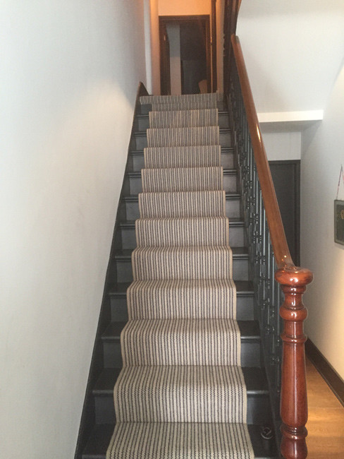 Photo of a mid-sized traditional carpeted u-shaped staircase in London with carpet risers and mixed railing.