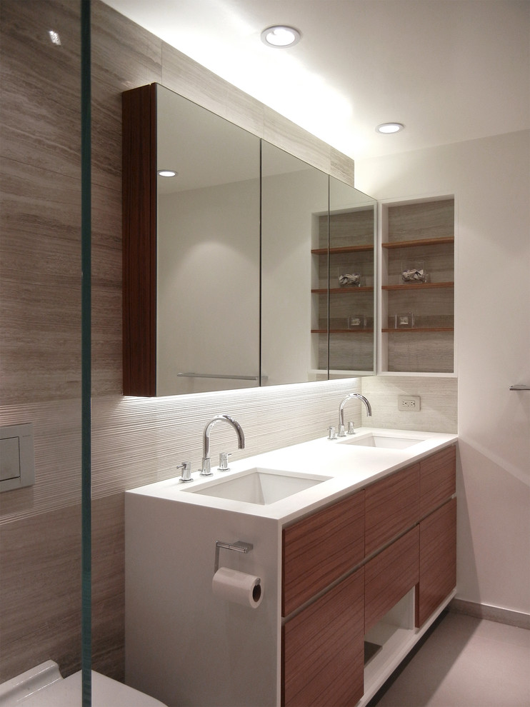 Inspiration for a large contemporary master bathroom in New York with an undermount sink, medium wood cabinets, an alcove shower, a wall-mount toilet, grey walls, flat-panel cabinets, concrete floors and solid surface benchtops.