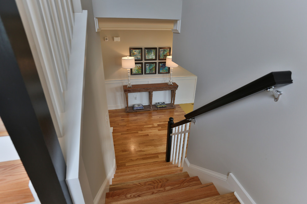 Transitional wood u-shaped staircase in Raleigh with painted wood risers.