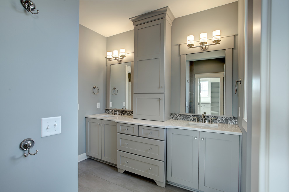 Inspiration for a small arts and crafts master bathroom in Grand Rapids with shaker cabinets, medium wood cabinets, gray tile, mosaic tile, blue walls, medium hardwood floors, an undermount sink, solid surface benchtops and beige floor.