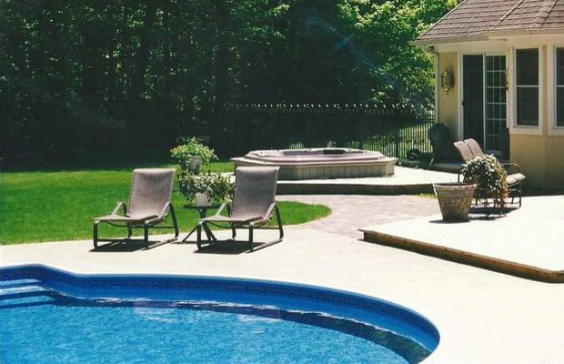 Large backyard custom-shaped hot tub photo in Grand Rapids