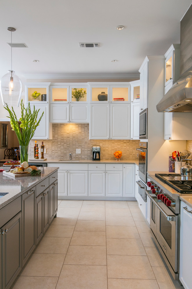 Inspiration for a transitional l-shaped eat-in kitchen in Dallas with an undermount sink, raised-panel cabinets, white cabinets, beige splashback, stainless steel appliances, with island, quartz benchtops, ceramic floors and stone tile splashback.