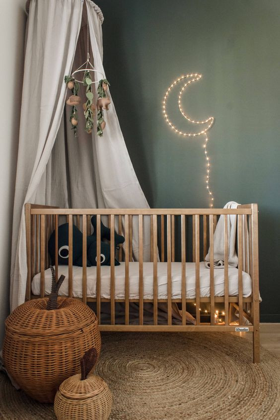 Medium sized farmhouse gender neutral nursery in Other with green walls, light hardwood flooring and brown floors.