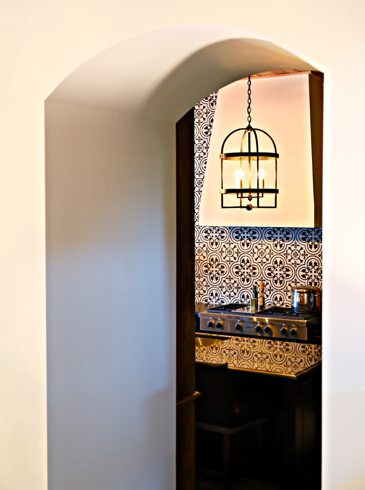 Inspiration for a mid-sized timeless l-shaped ceramic tile eat-in kitchen remodel in Tampa with a single-bowl sink, black cabinets, multicolored backsplash, ceramic backsplash, stainless steel appliances and white walls