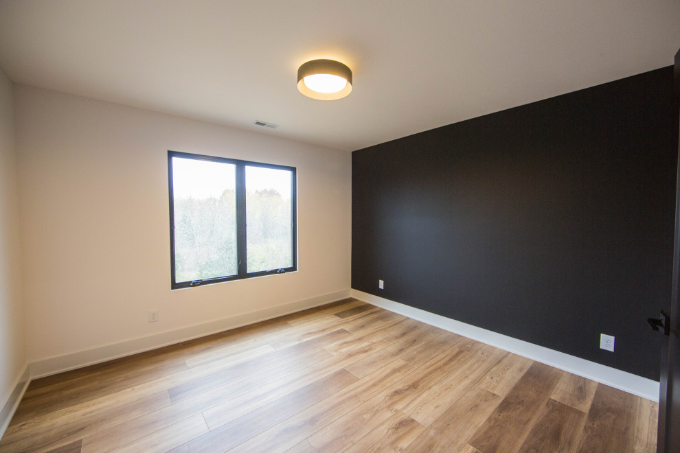Exemple d'une grande chambre d'amis tendance avec un mur blanc, un sol en bois brun et un sol marron.