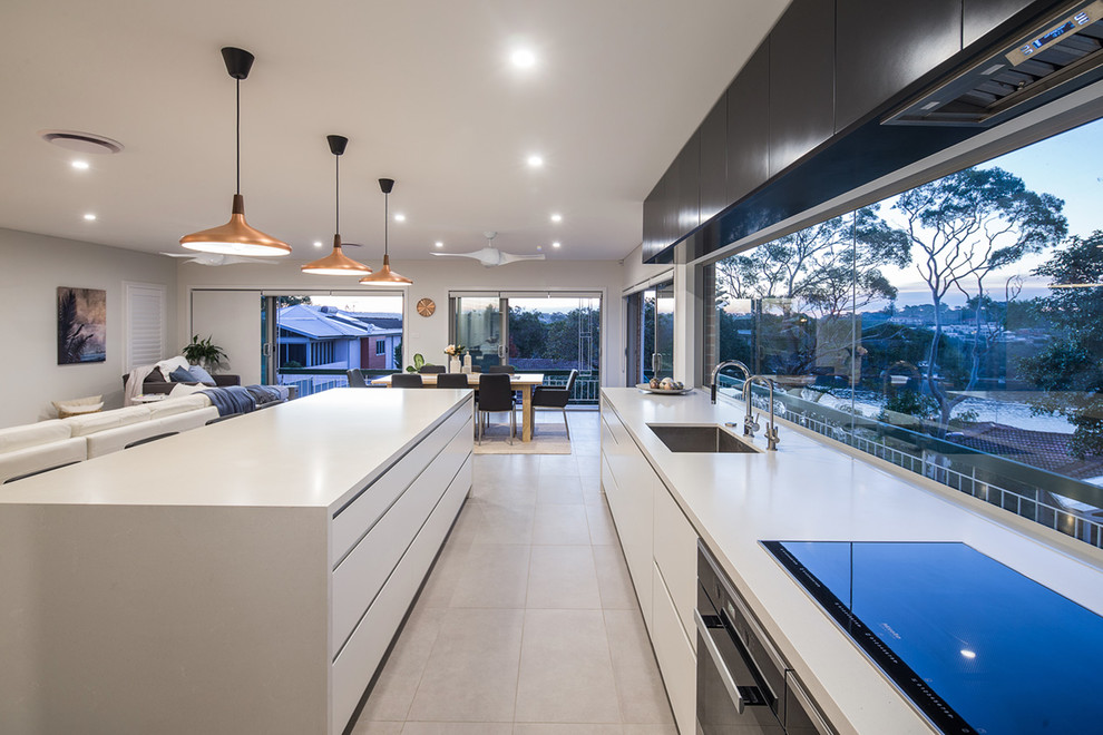 Expansive contemporary eat-in kitchen in Sydney with a single-bowl sink, flat-panel cabinets, white cabinets, stainless steel appliances, ceramic floors and with island.