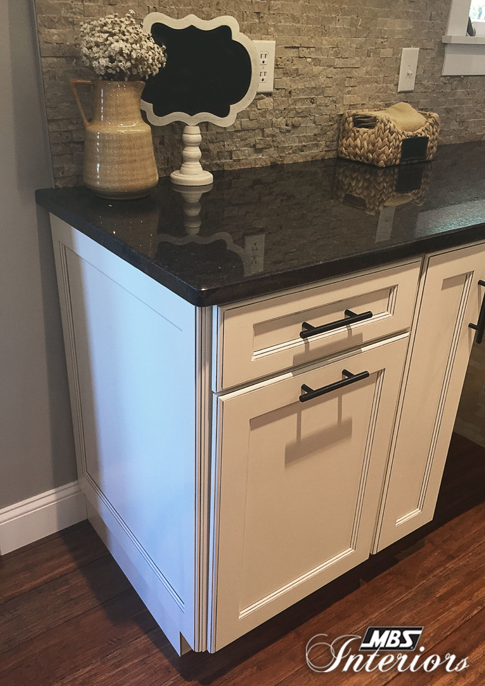 Inspiration for a mid-sized transitional u-shaped medium tone wood floor eat-in kitchen remodel in Cincinnati with an undermount sink, flat-panel cabinets, white cabinets, granite countertops, gray backsplash, stone tile backsplash, black appliances and no island