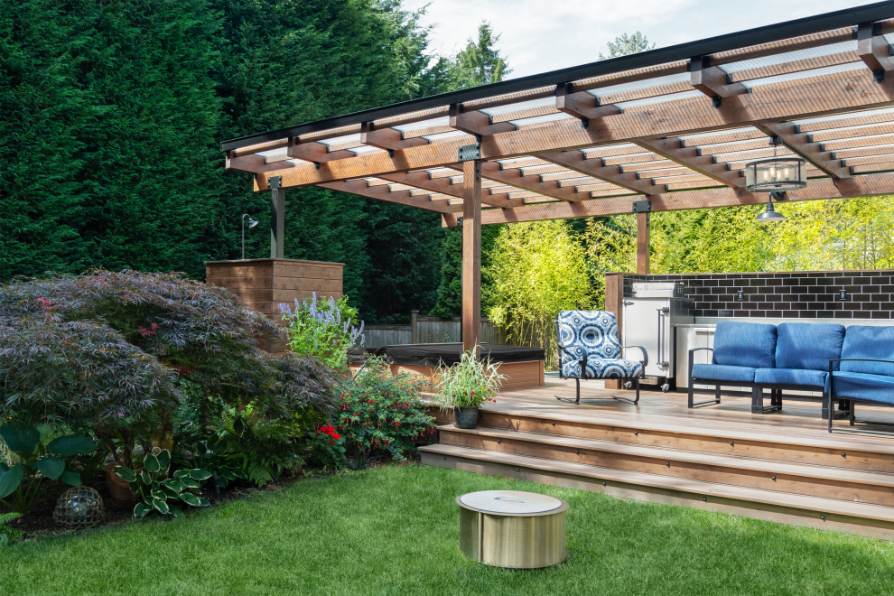 Modelo de terraza planta baja actual de tamaño medio en patio trasero con cocina exterior y pérgola