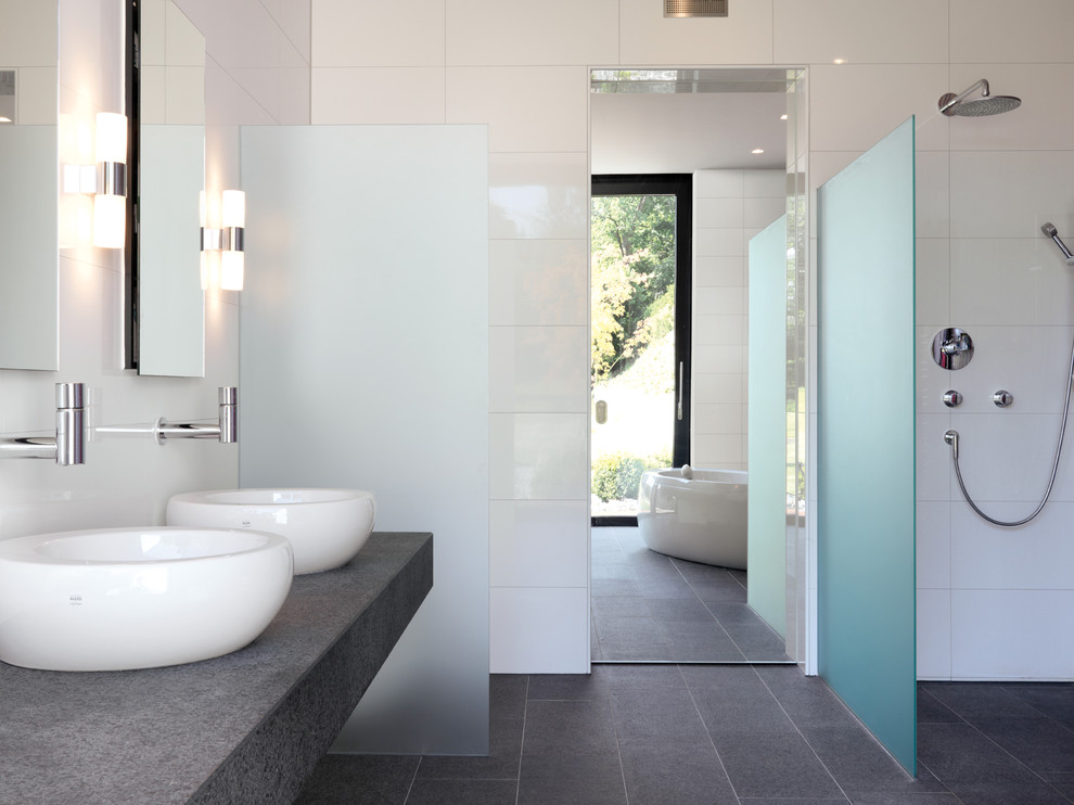 Large contemporary bathroom in Stuttgart with a vessel sink, a freestanding tub, an open shower, white tile, ceramic tile, an open shower and grey floor.