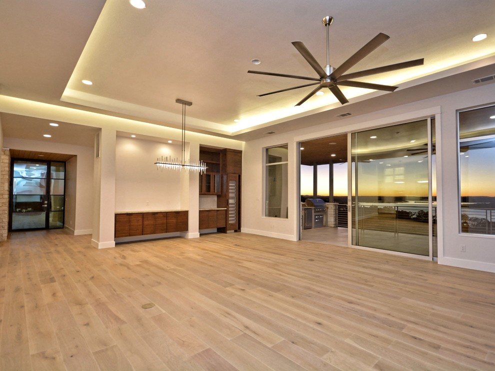 Mid-sized contemporary dining room in Austin with white walls, light hardwood floors and no fireplace.